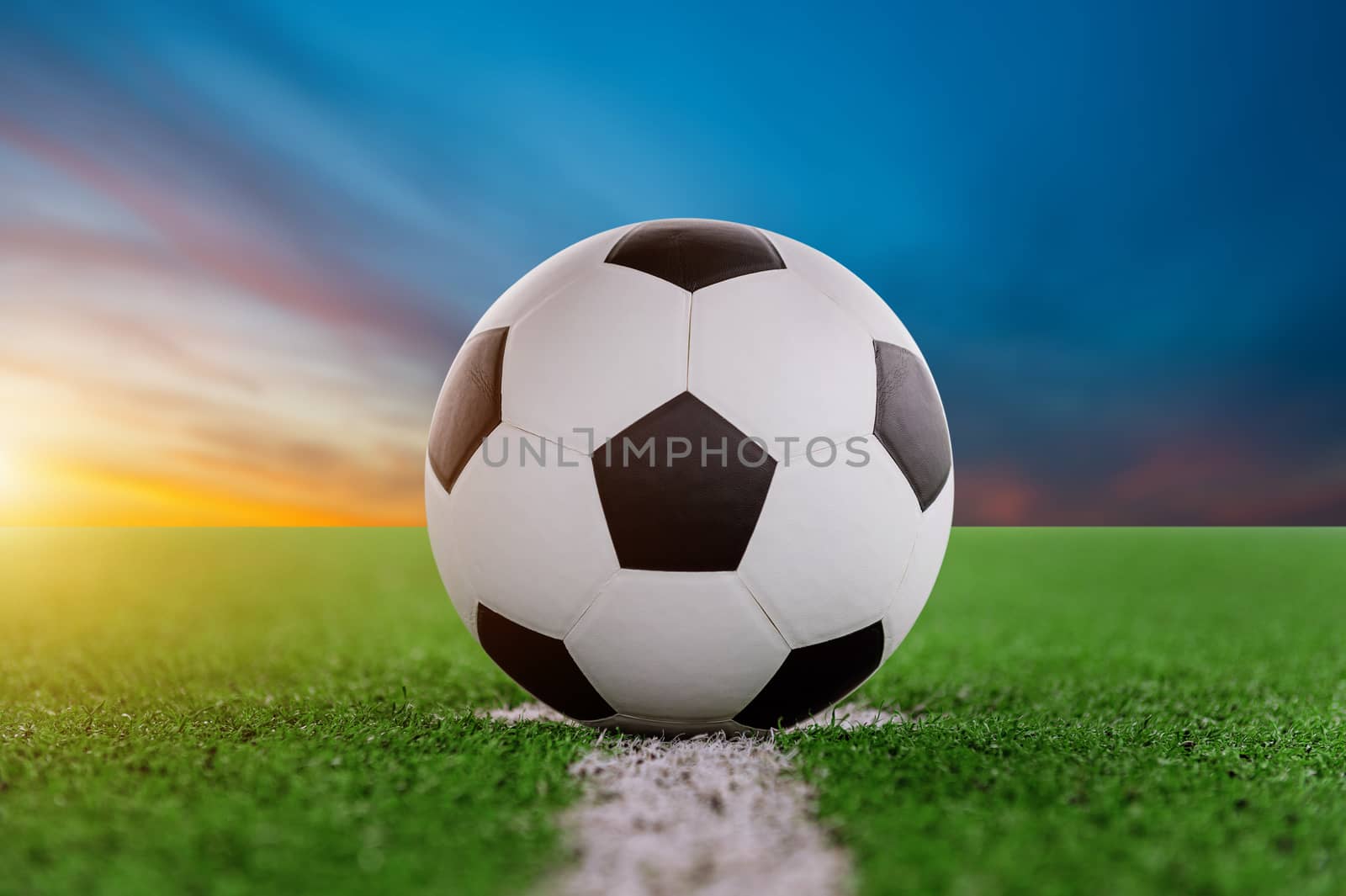 soccer ball on soccer field at sunset.