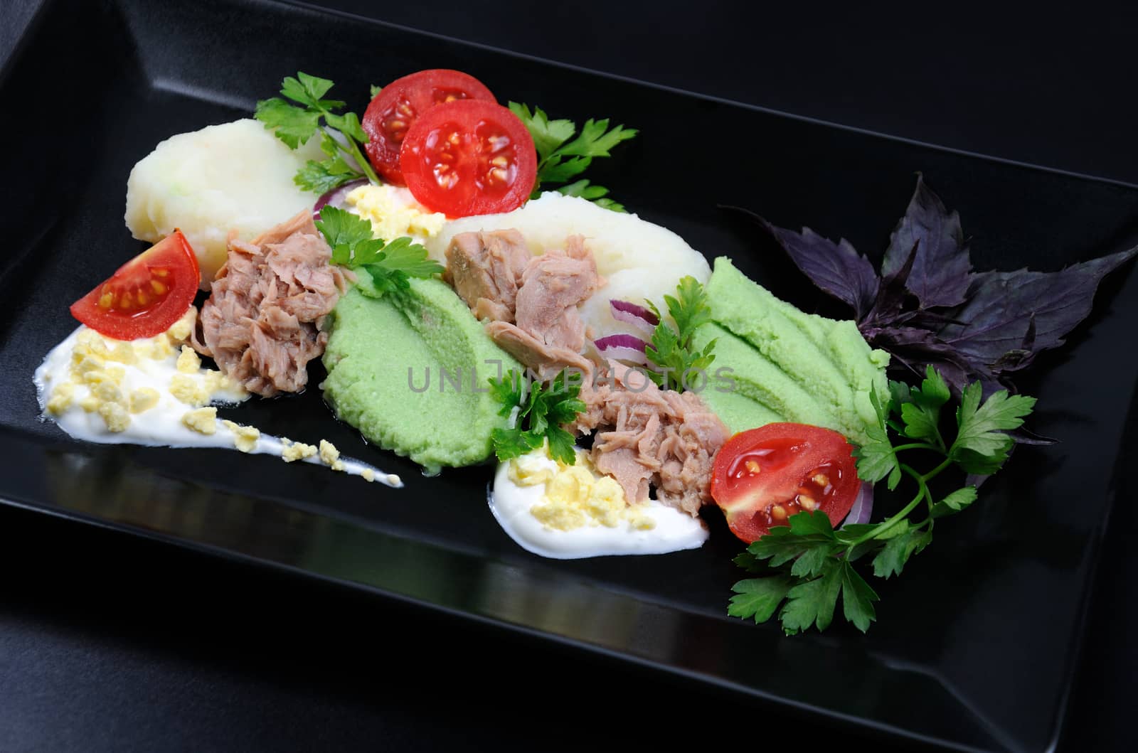 Canned tuna with garnish of mashed potatoes with avocado.