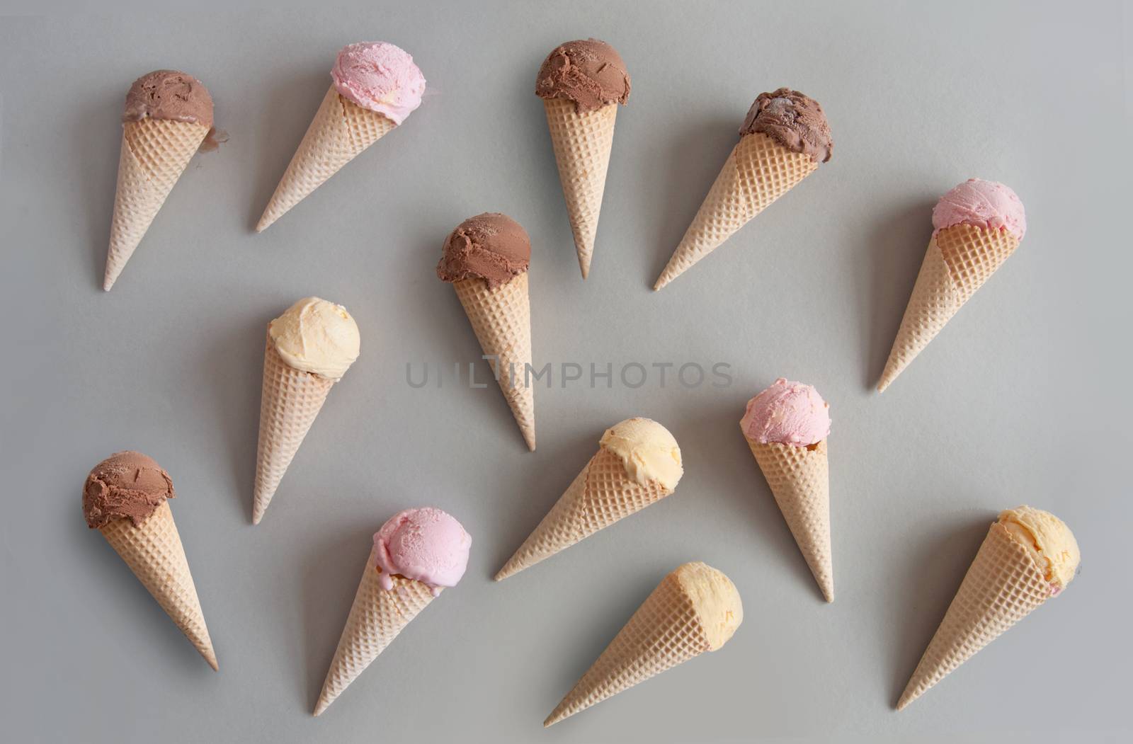 Many chocolate, vanilla and strawberry ice cream cones 