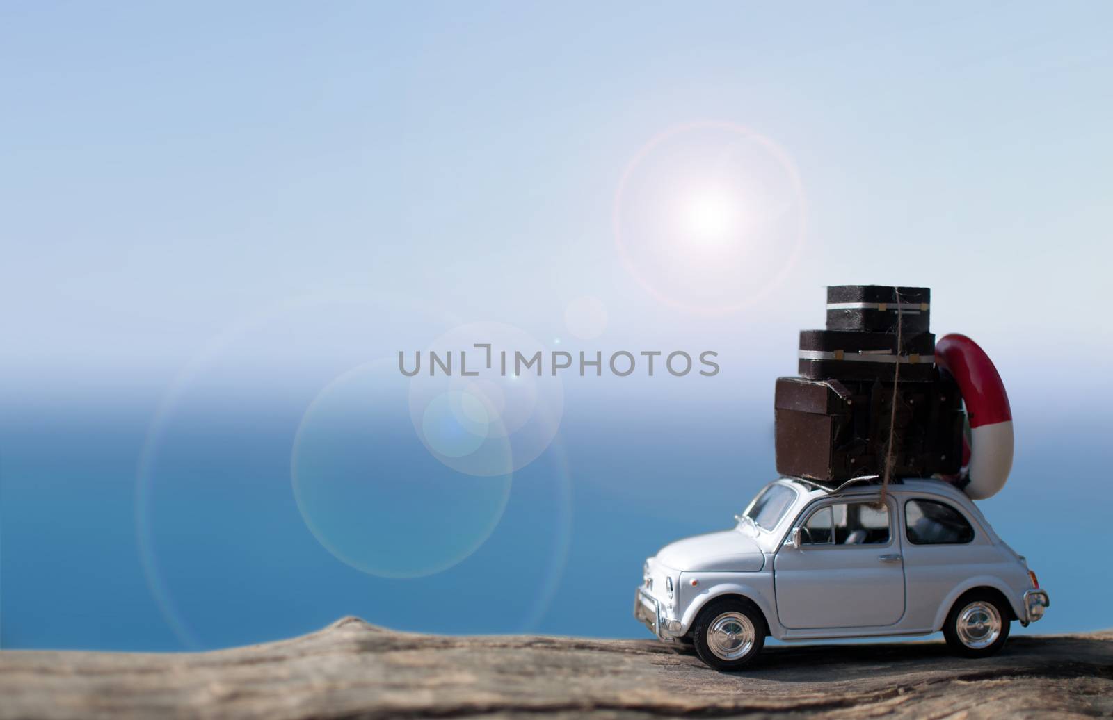 Miniature car with suitcases by the sea 