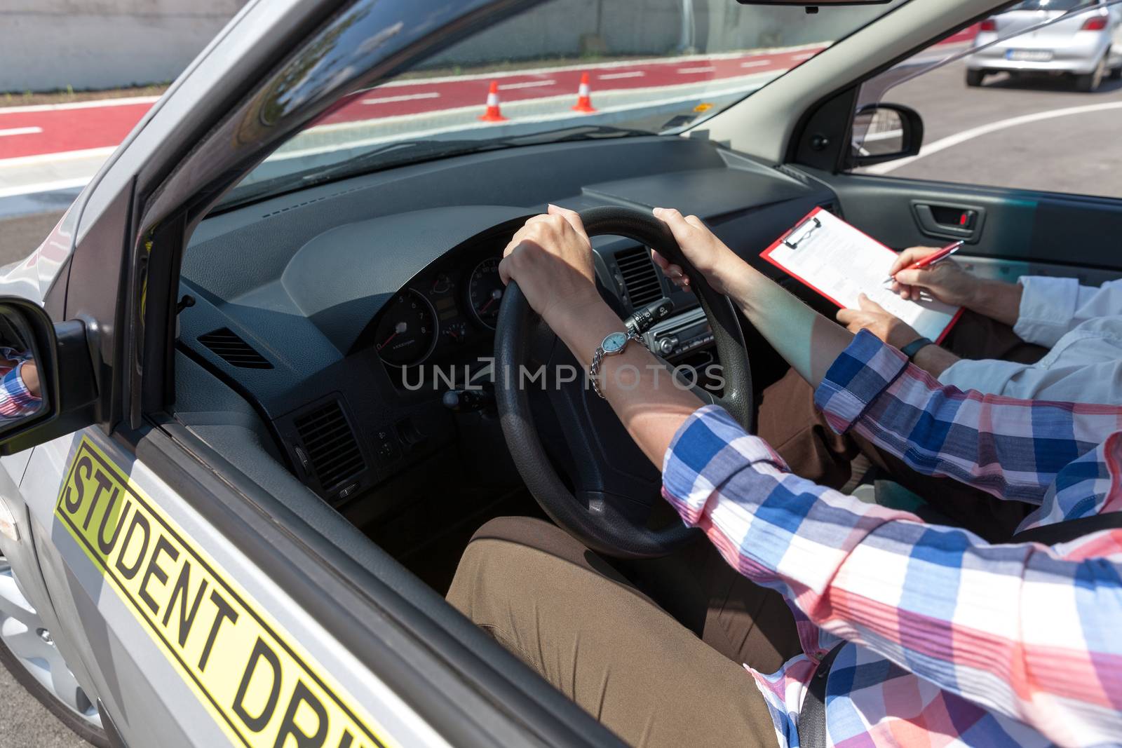 Learner driver student driving car with instructor by wellphoto
