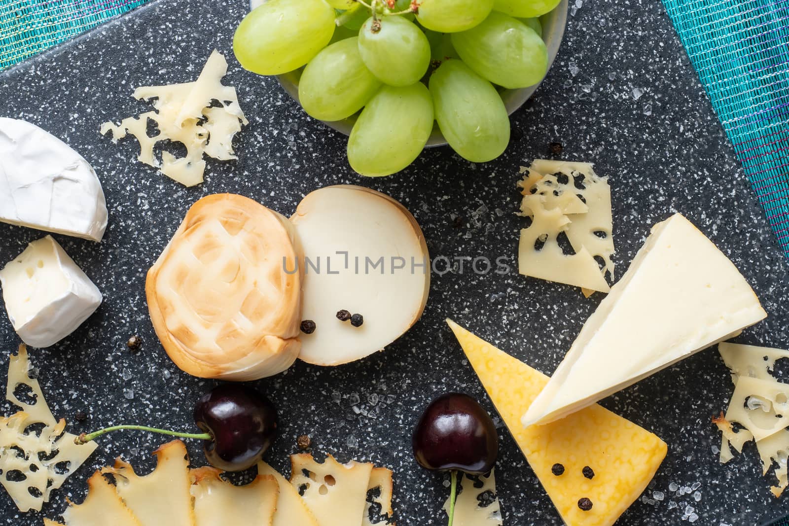 Cold appetizer. Cold cuts. Cheese on cutting board isolated on blue background, top view