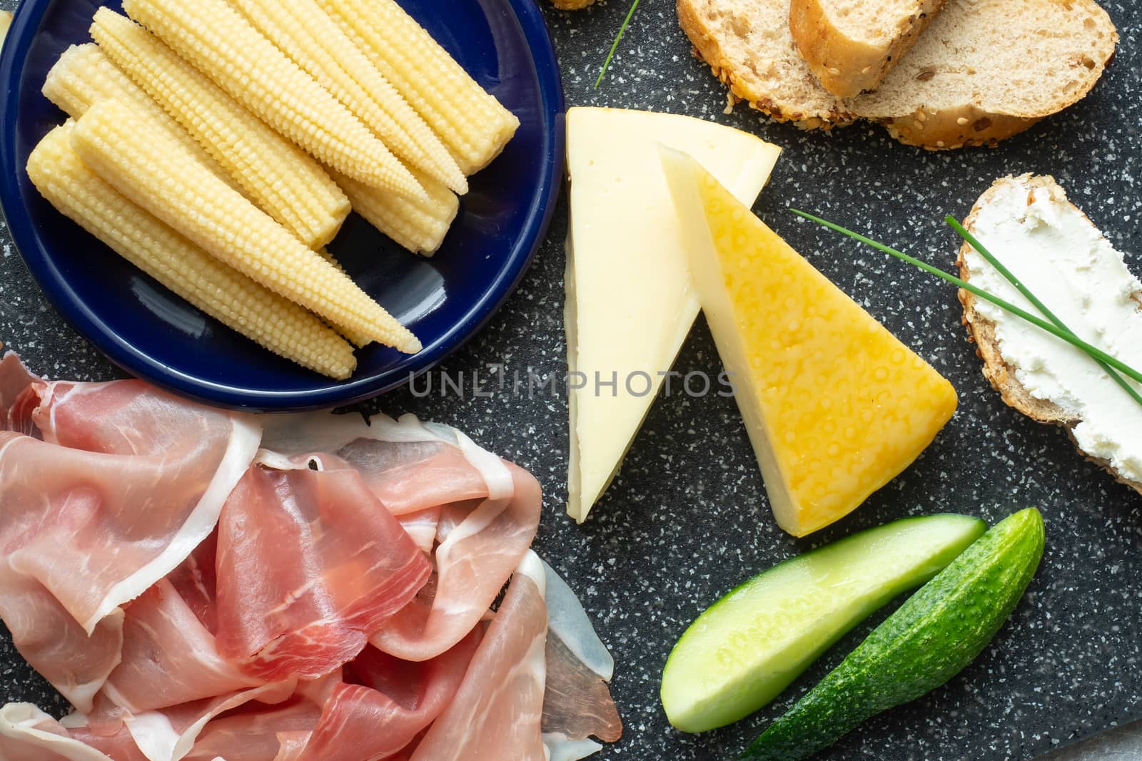 Cold appetizer. Cold cuts. Spicy food on black background, top view.