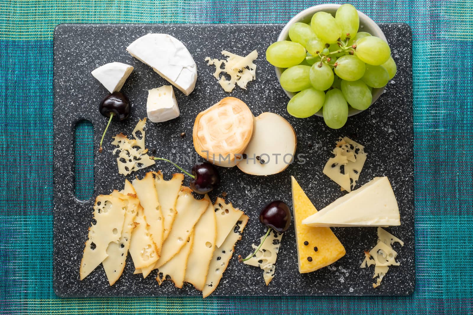 Cold appetizer. Cold cuts. Cheese on cutting board isolated on blue background, top view