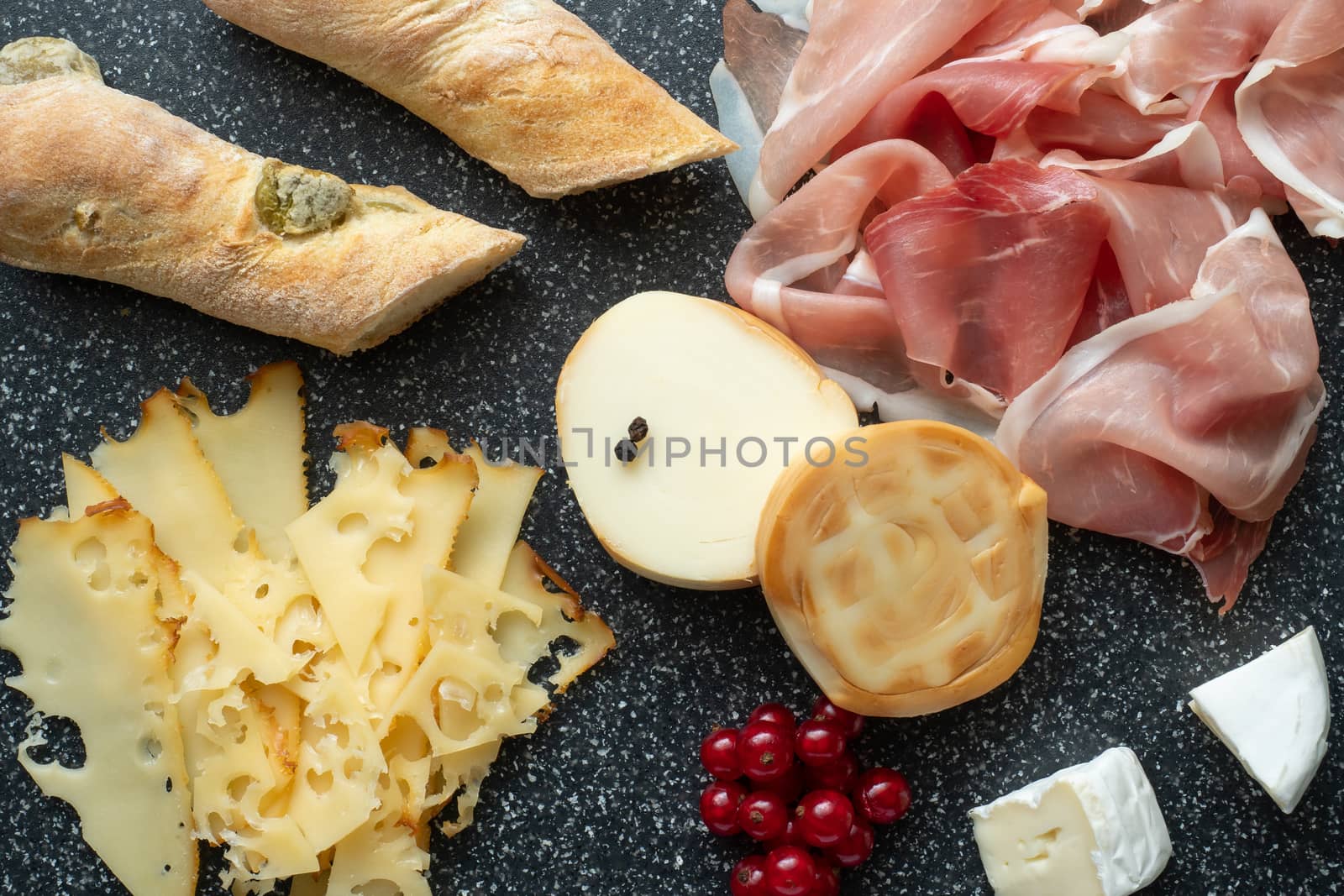 Cold appetizer. Cold cuts. Spicy food on black background.