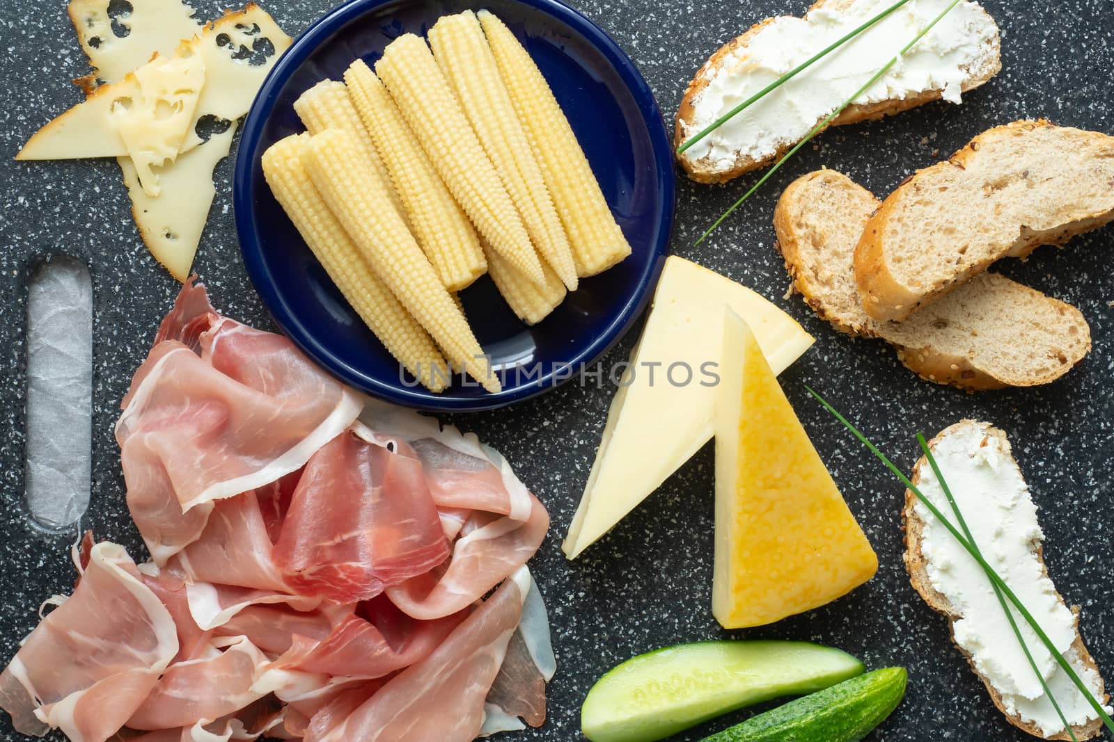 Cold appetizer. Cold cuts. Spicy food on black background, top view.