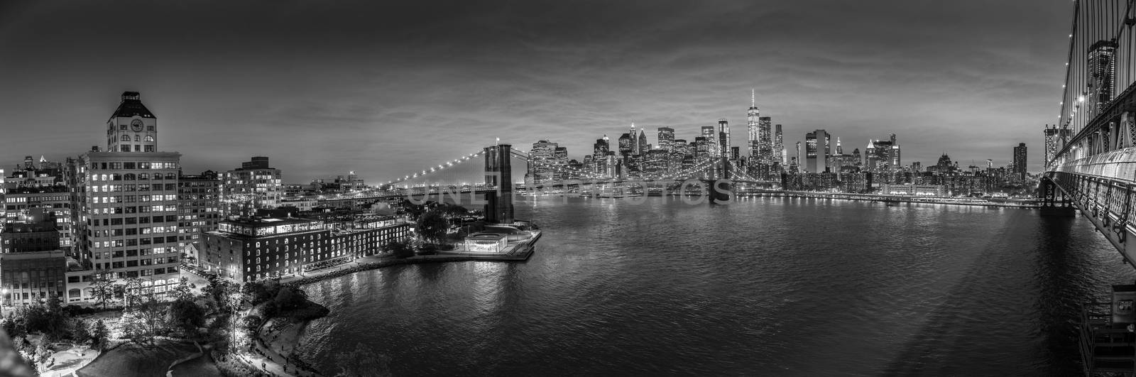 Brooklyn, Brooklyn park, Brooklyn Bridge, Janes Carousel and Lower Manhattan skyline at night seen from Manhattan bridge, New York city, USA. Black and white wide angle panoramic image.
