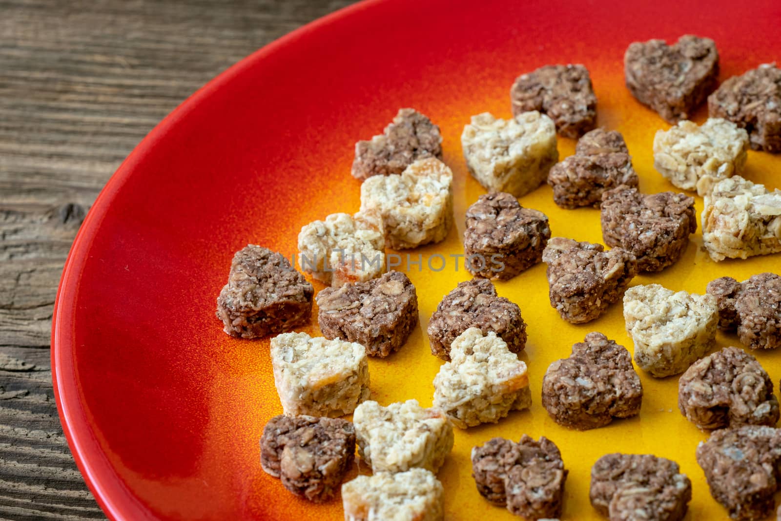 Plate with heart shaped cookies on wooden table