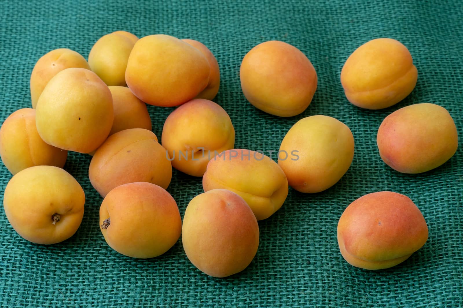 Ripe apricots. Green background. Food for a vegan and a vegetarian. Diet, detox, food concept.