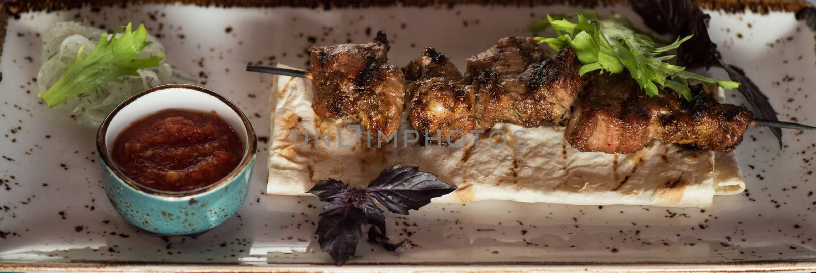 shashlik on a barbecue skewer with sauce by rusak