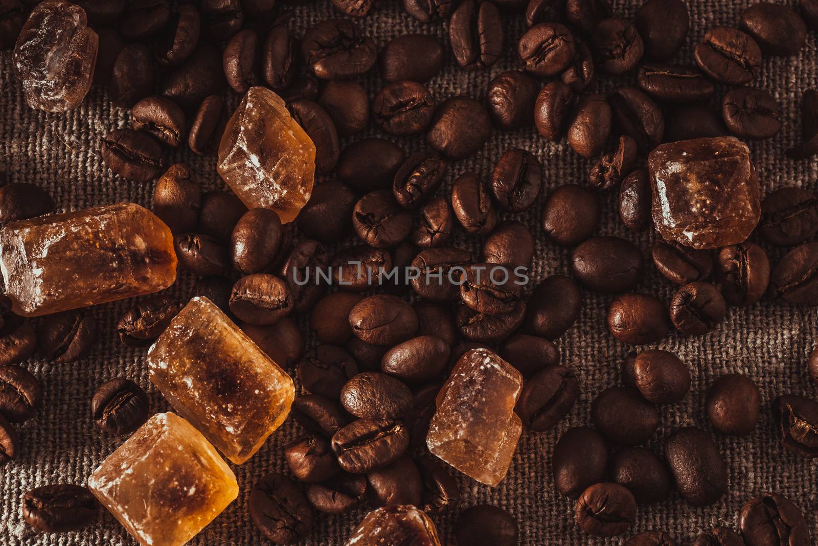 scattering of coffee beans and dark candy sugar on textile