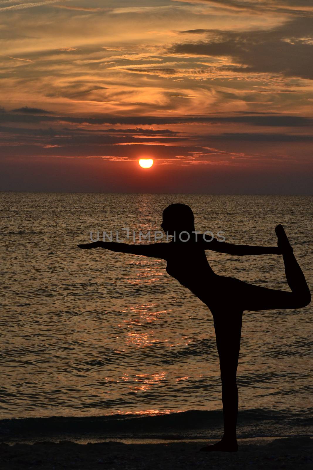 Warrior pose from yoga by woman silhouette on sunrise