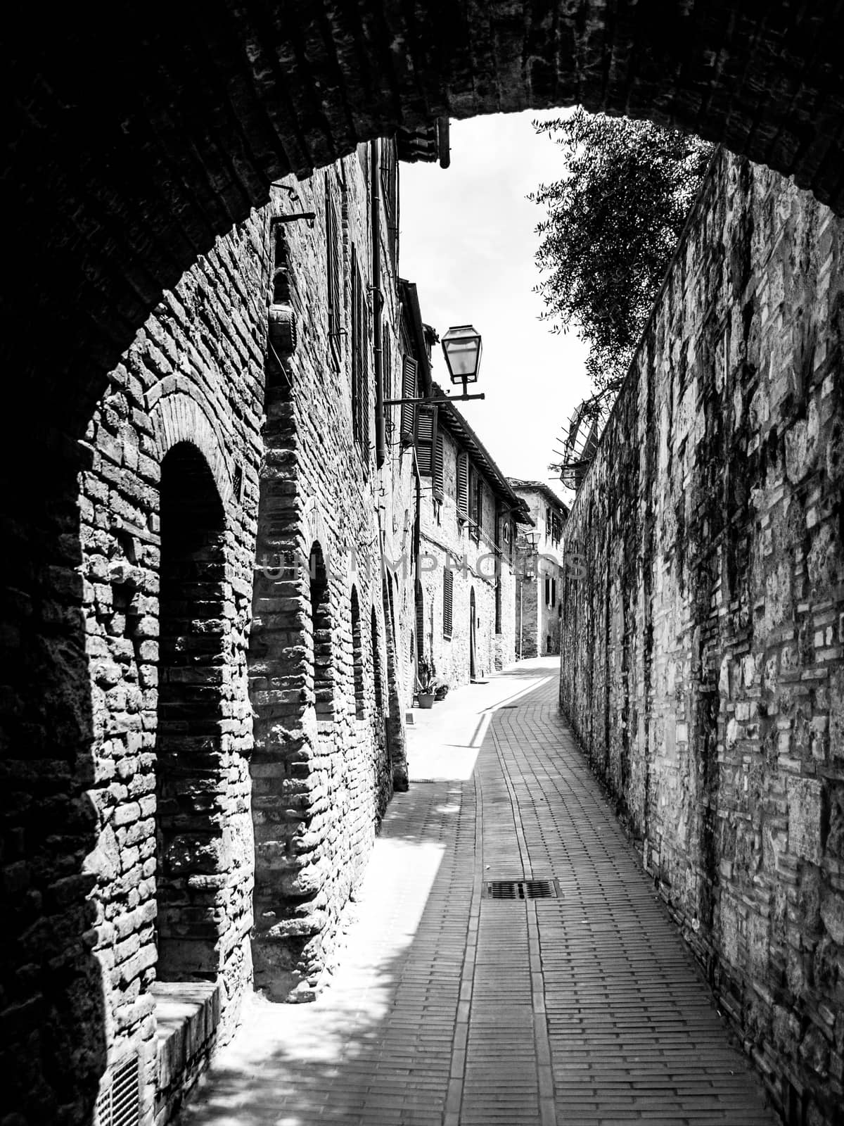 Picturesque medieval narrow street of San Gimignano old town, Tuscany, Italy by pyty