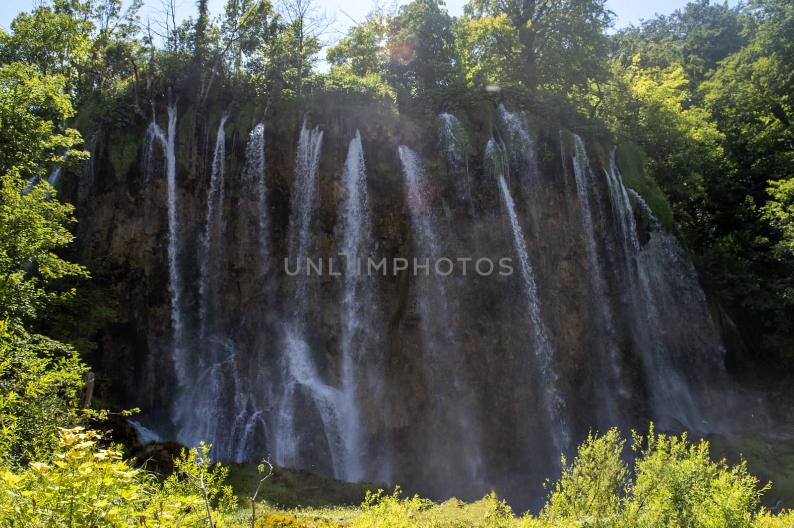 Big waterfalls and green trees in Plitvice in summer.