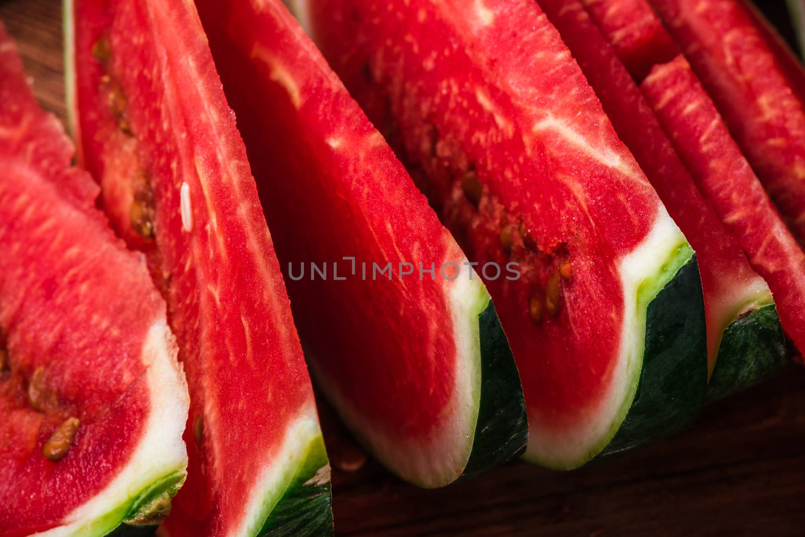 Juicy watermelon slices lying on wooden surface by Seva_blsv