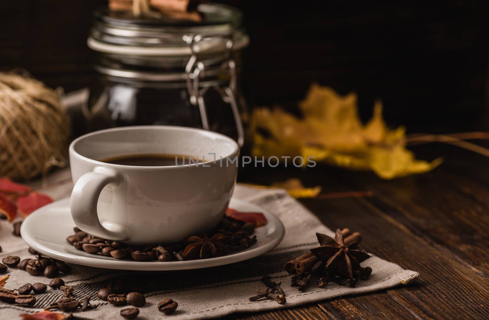 Cup of coffee with ingredients, spices and some kitchenware at autumn evening.