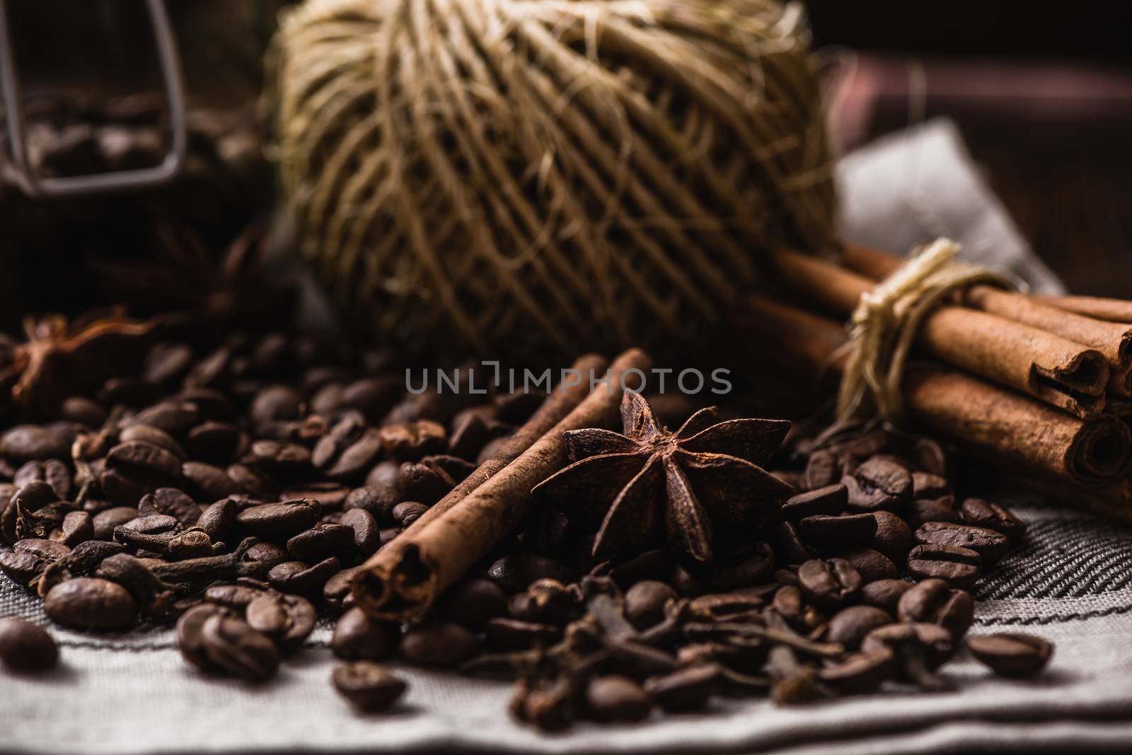 Coffee beans with autumn spices on the tablecloth. Warming and fragrant set.