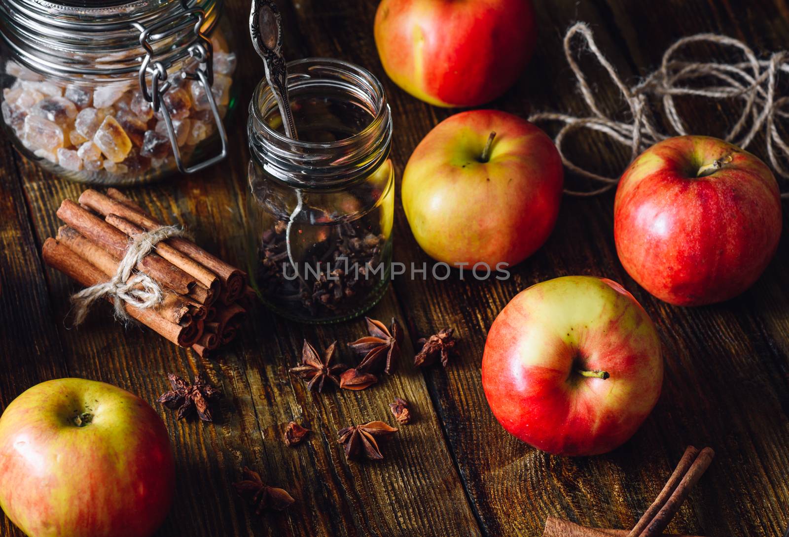 Red Apples with Different Spices on Wooden Table.