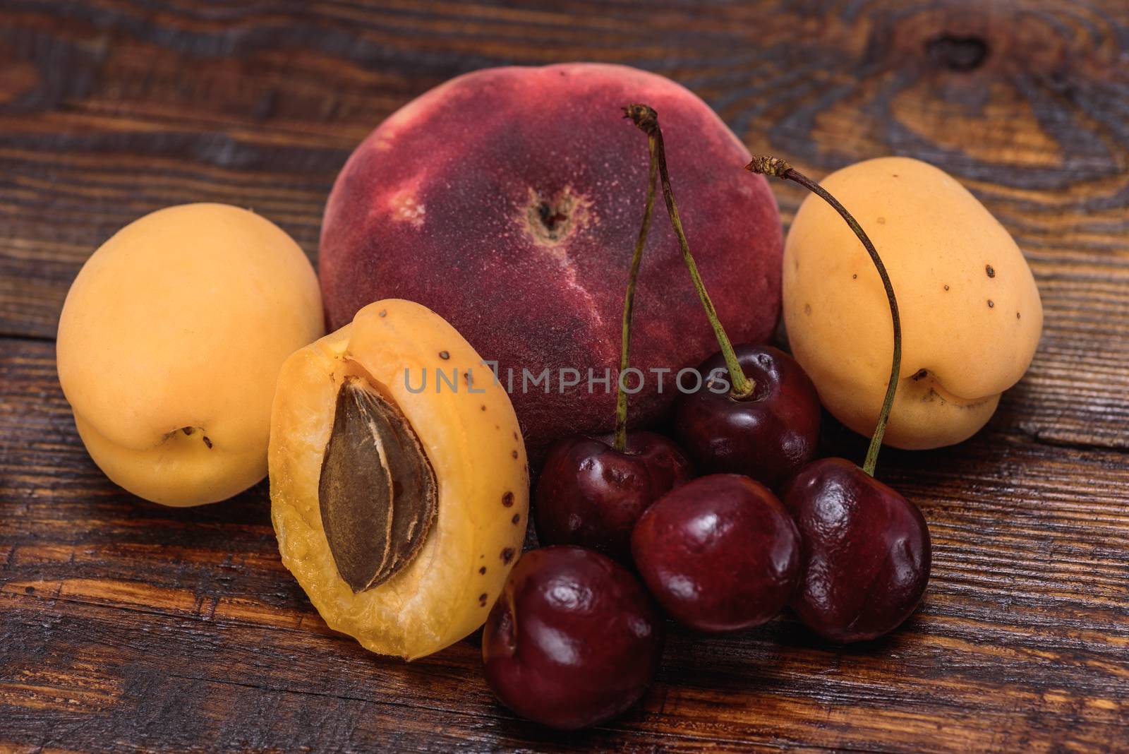 Ripe and sweet fruits on dark wooden background by Seva_blsv