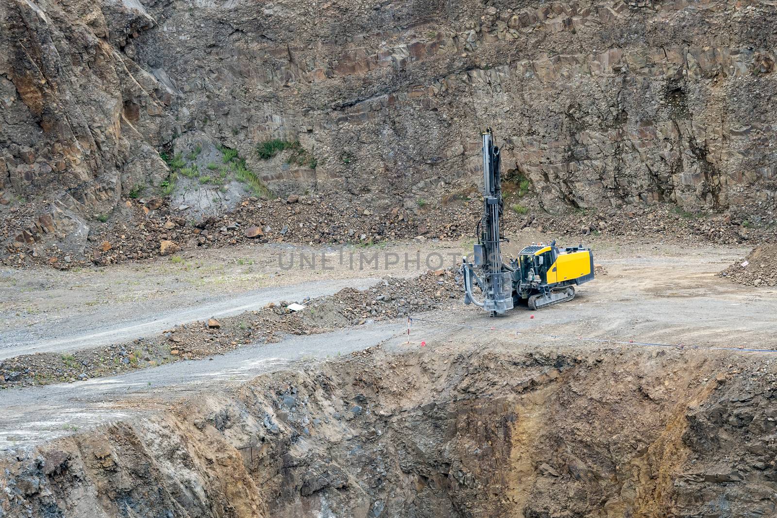 Opencast mining quarry with mining drilling machine. Mining in the granite quarry. Mining industry.