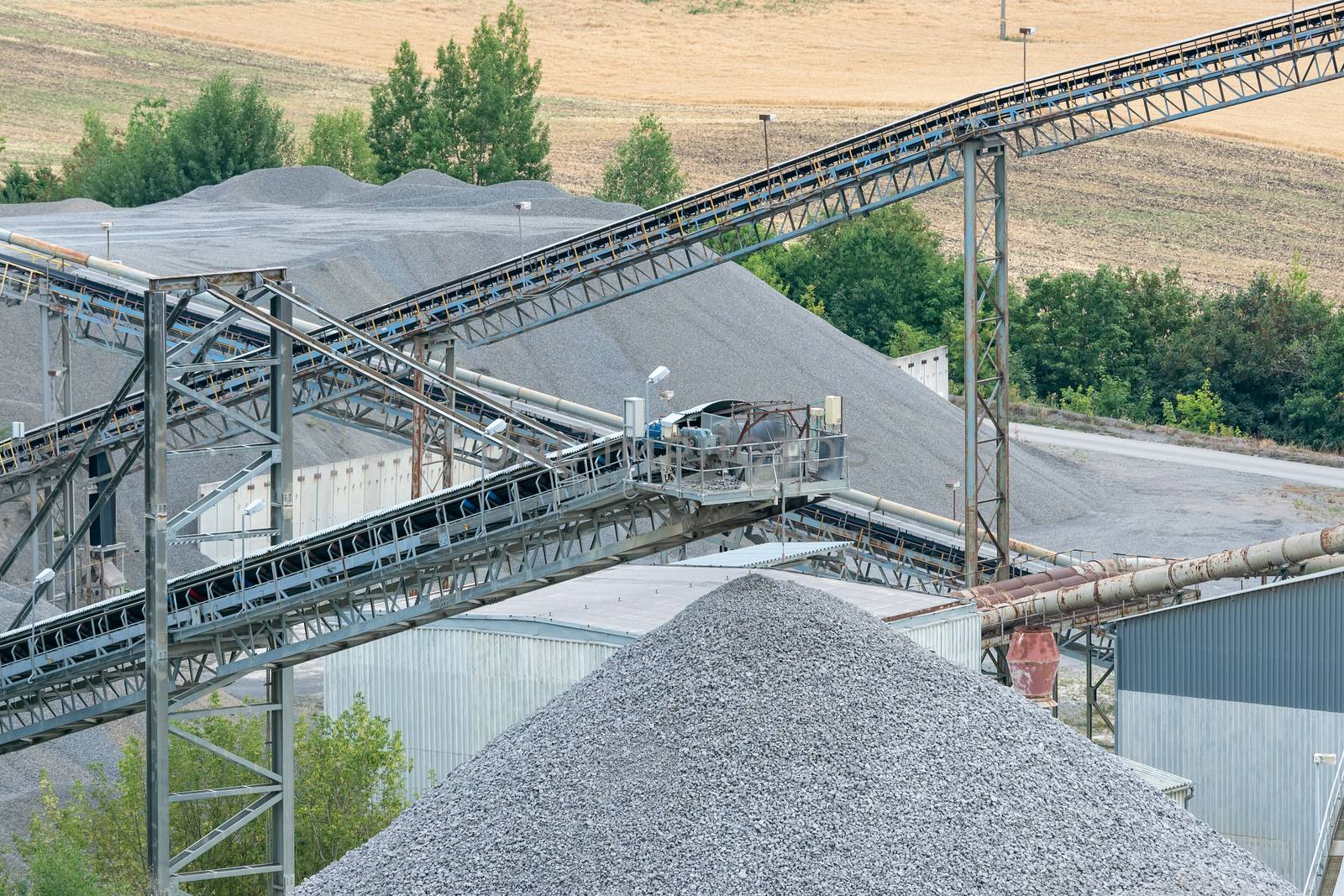 Belt conveyors and mining equipment in a quarry. Stone quarry with conveyor belts and piles of stones. Quarrying of stones for construction works.