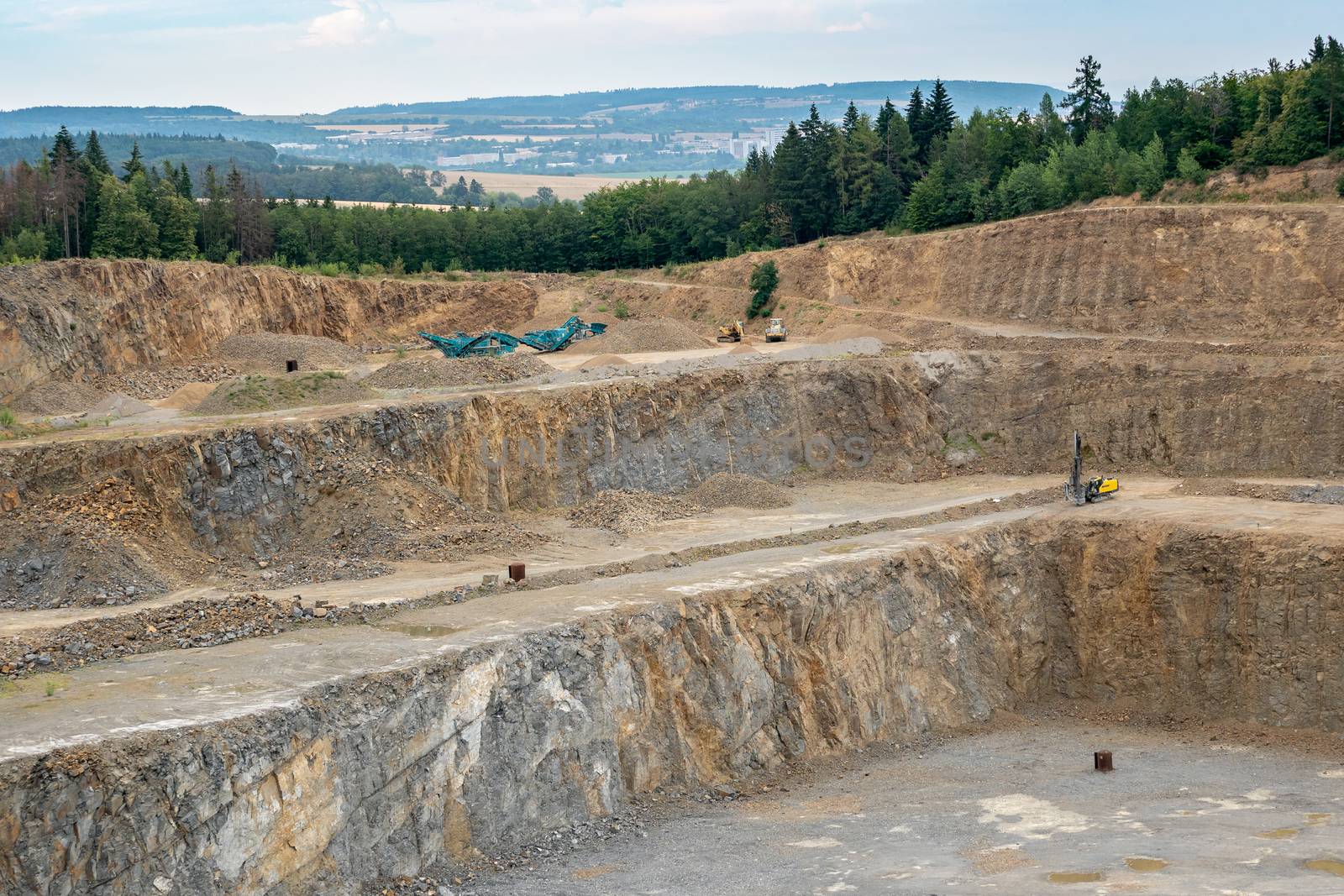 Opencast mining quarry with lots of machinery. Mining in the gra by xtrekx