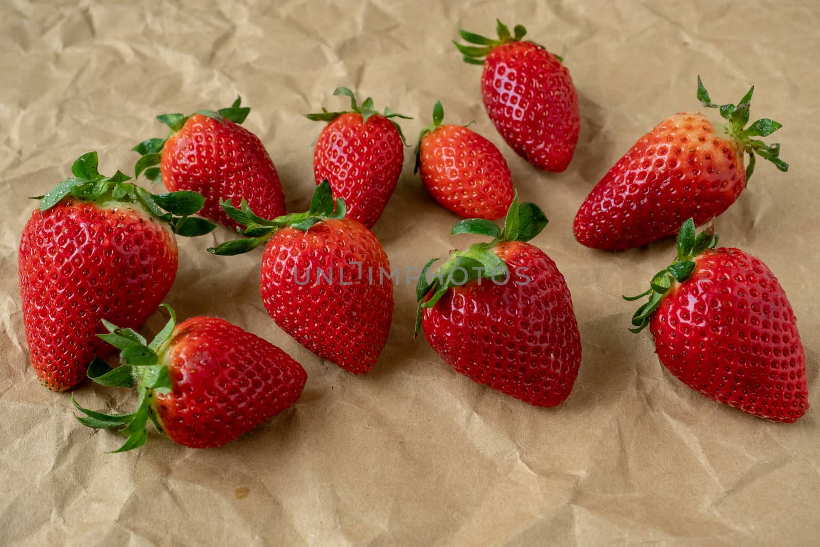 Fresh strawberries on the brown paper by xtrekx