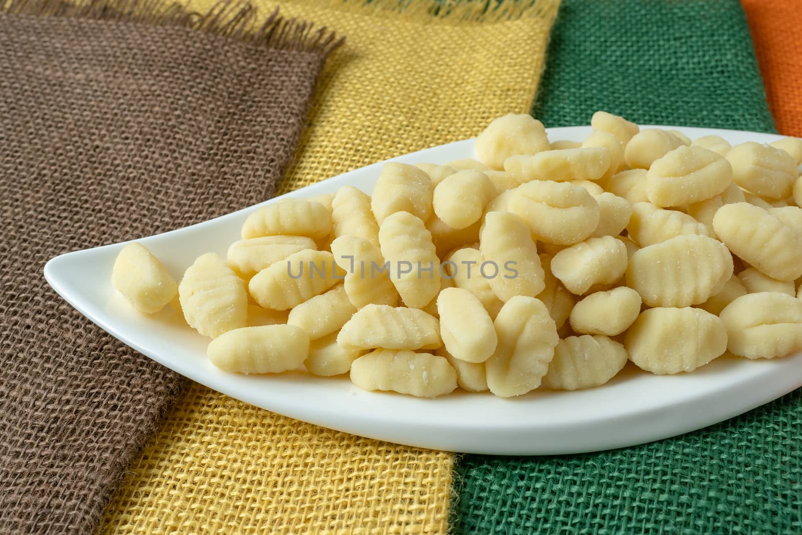 Uncooked homemade potato gnocchi in a white bowl by xtrekx