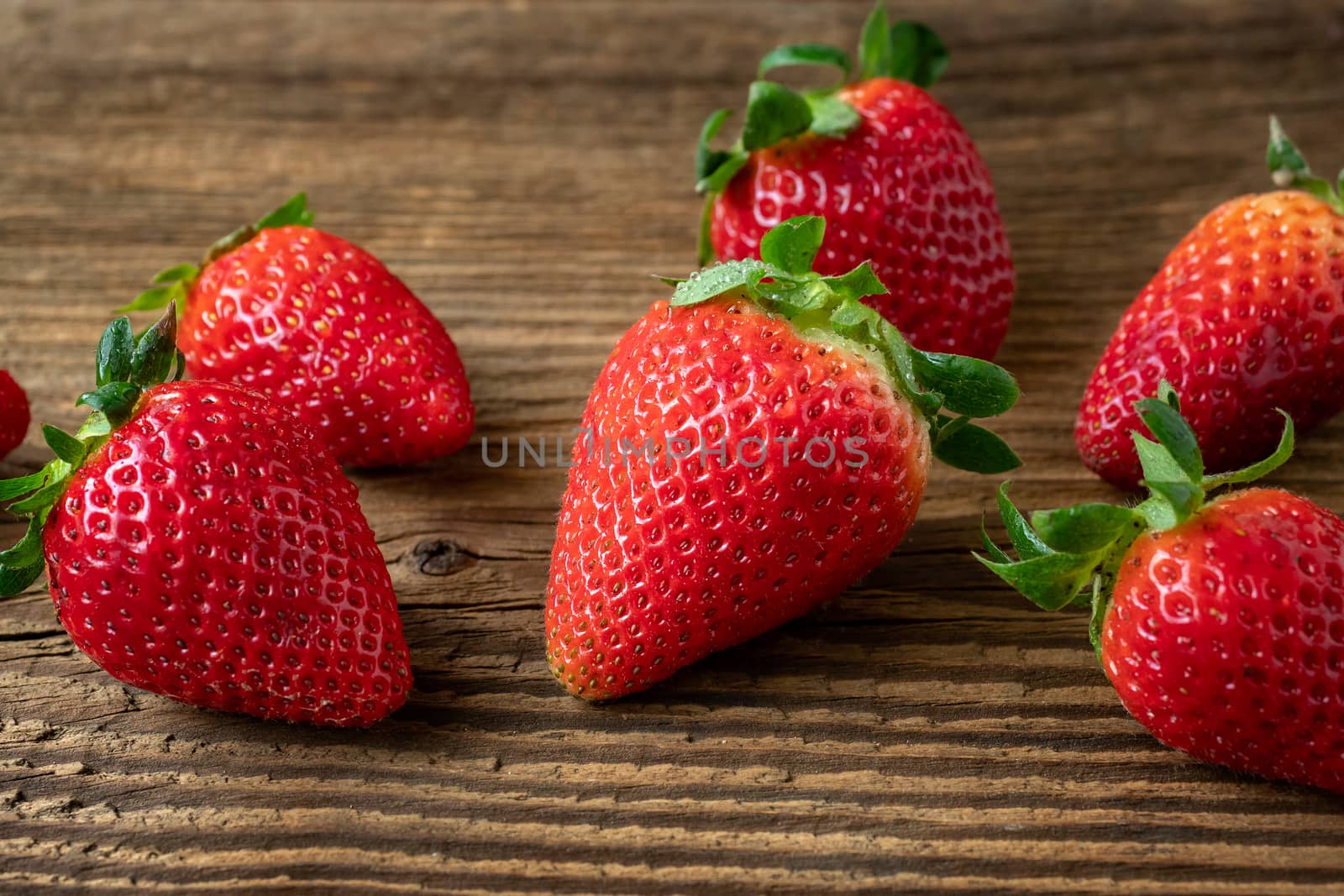 Ripe strawberries on a wooden table by xtrekx