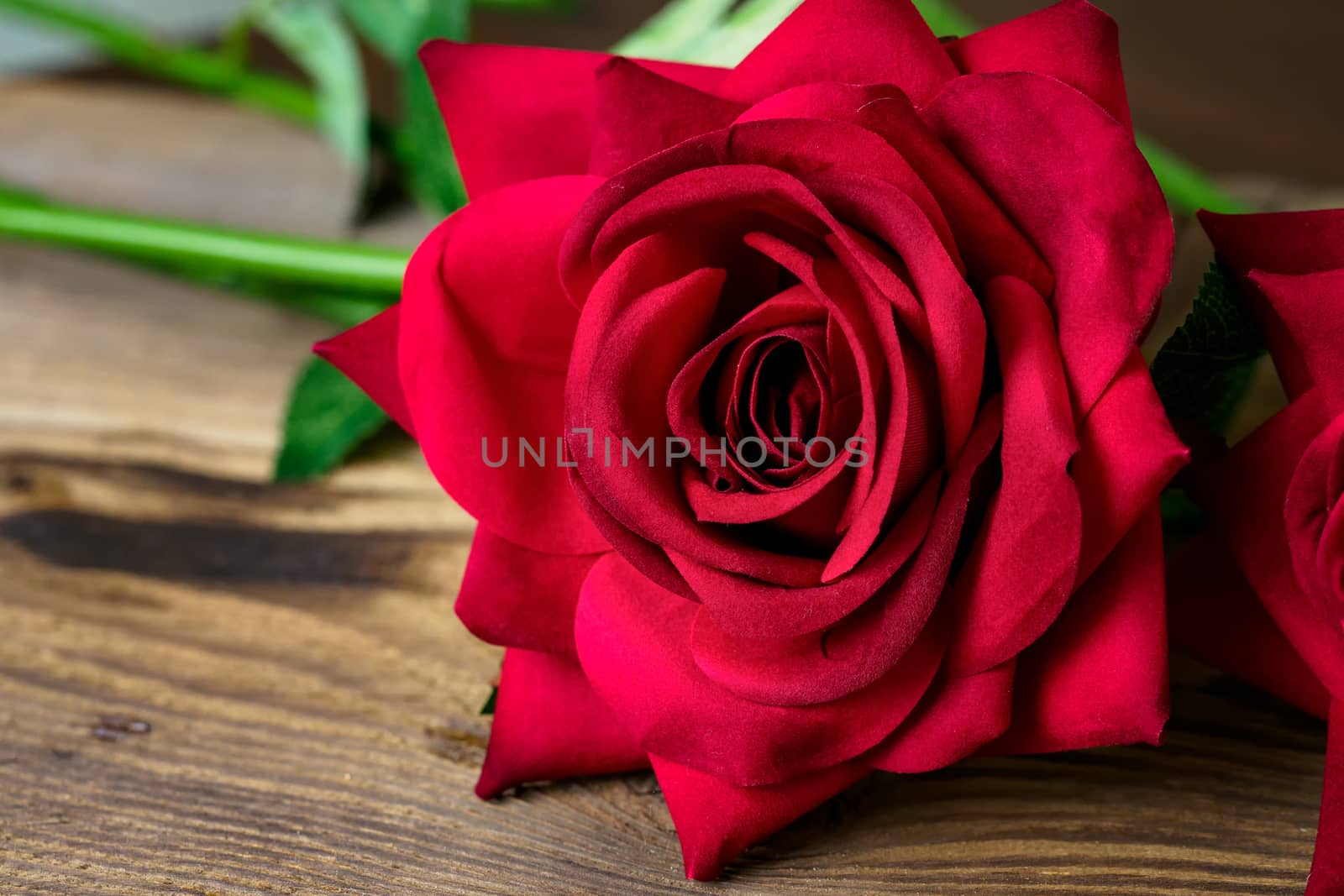 Red rose from fabric on a old wooden table