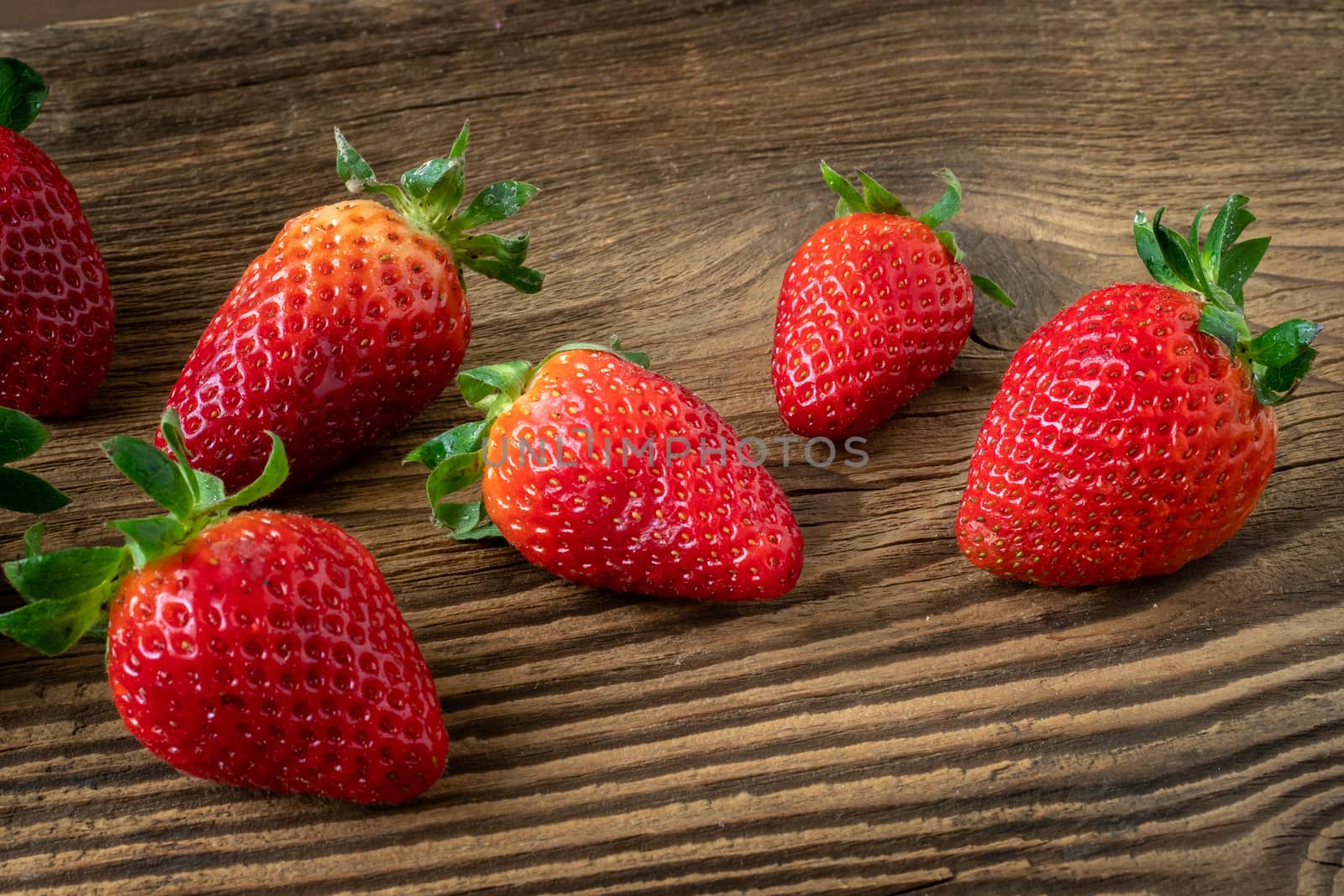 Ripe strawberries on a wooden table by xtrekx