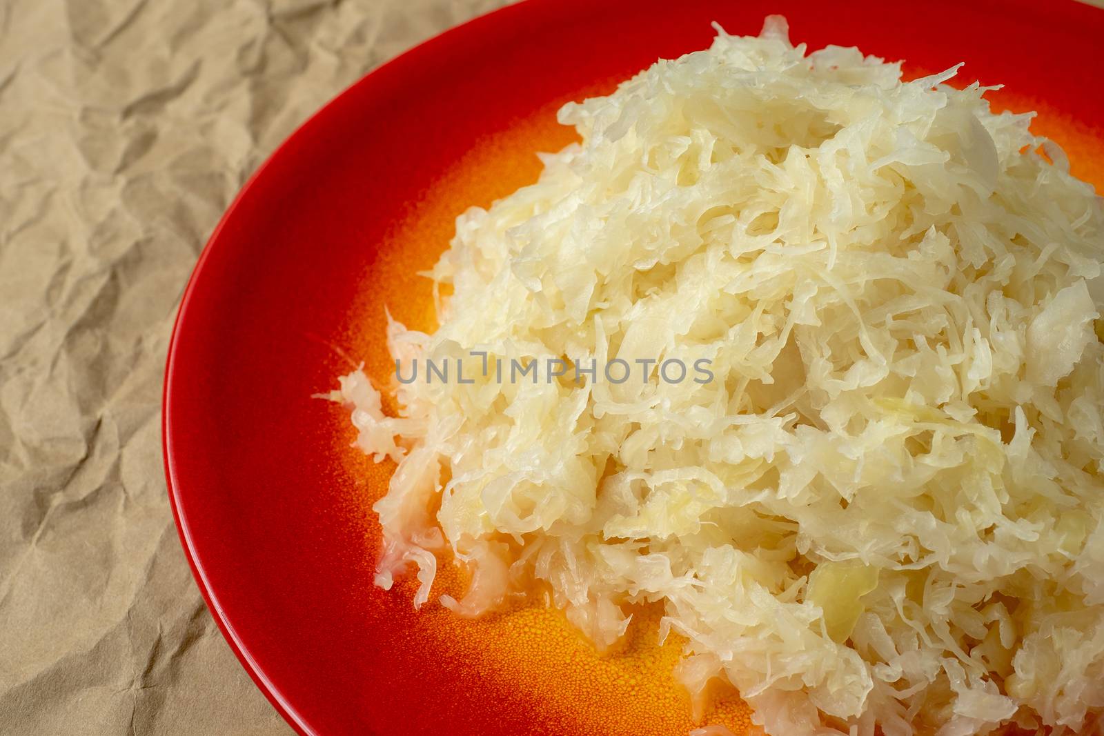 Fermented cabbage. Red plate of sauerkraut (pickled white cabbage).