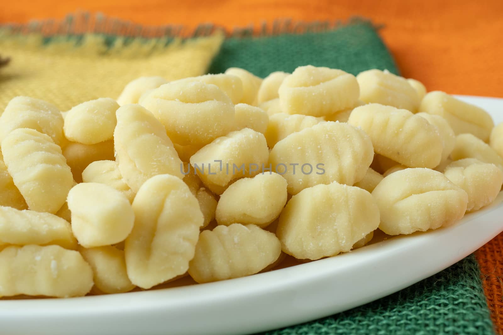 Uncooked homemade potato gnocchi in a white bowl by xtrekx