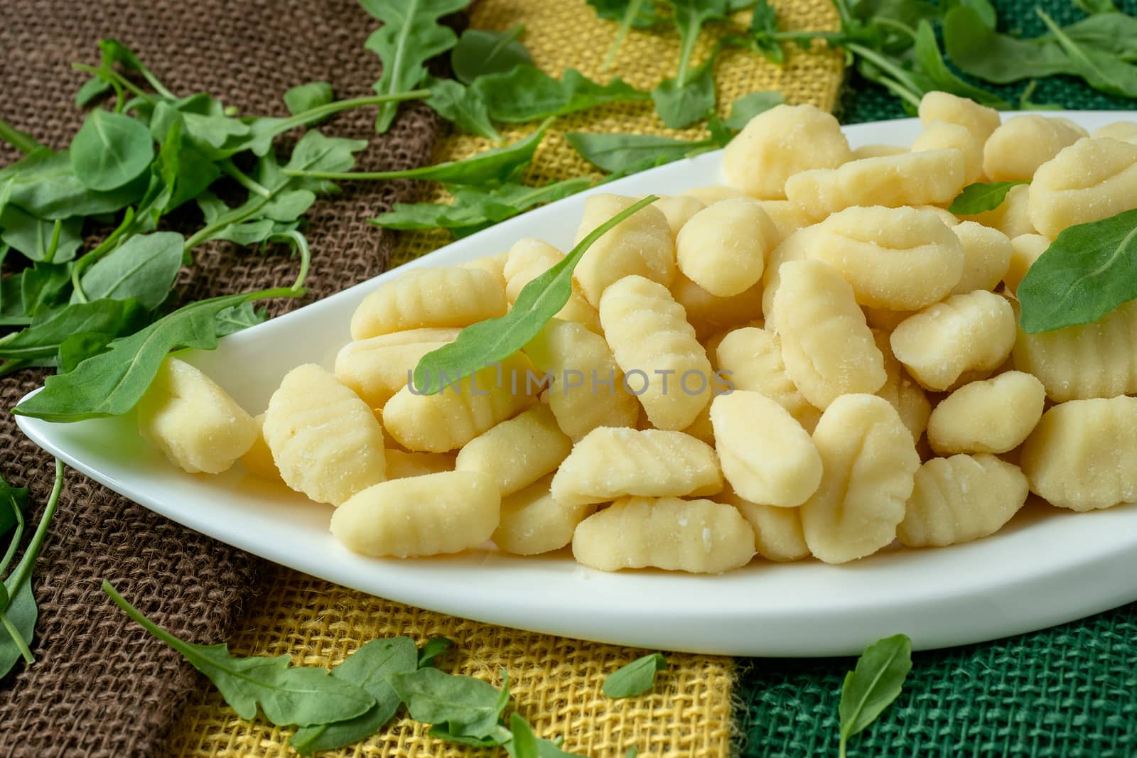 Uncooked homemade potato gnocchi in a white plate