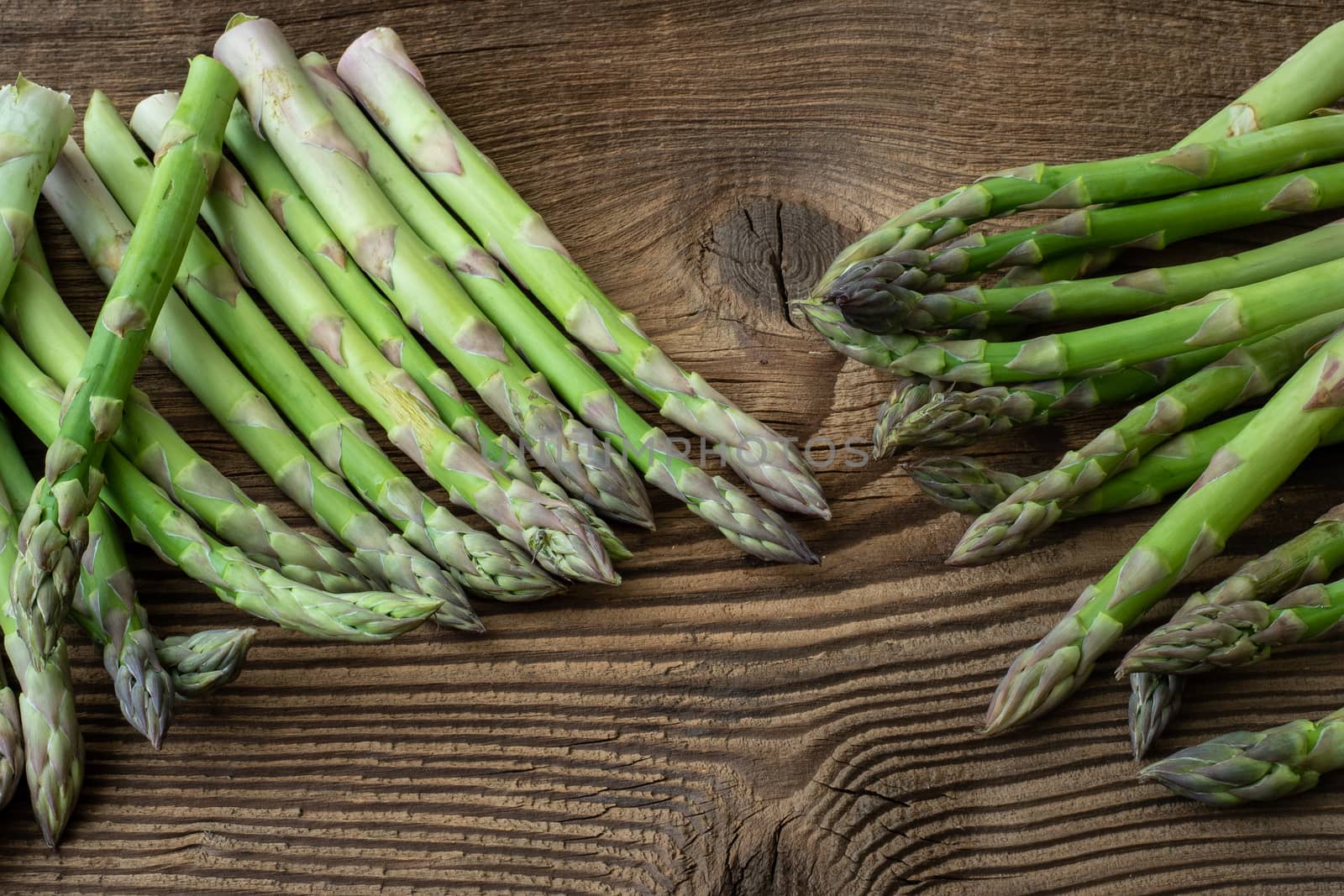 Raw garden asparagus stems. Fresh green spring vegetables on woo by xtrekx