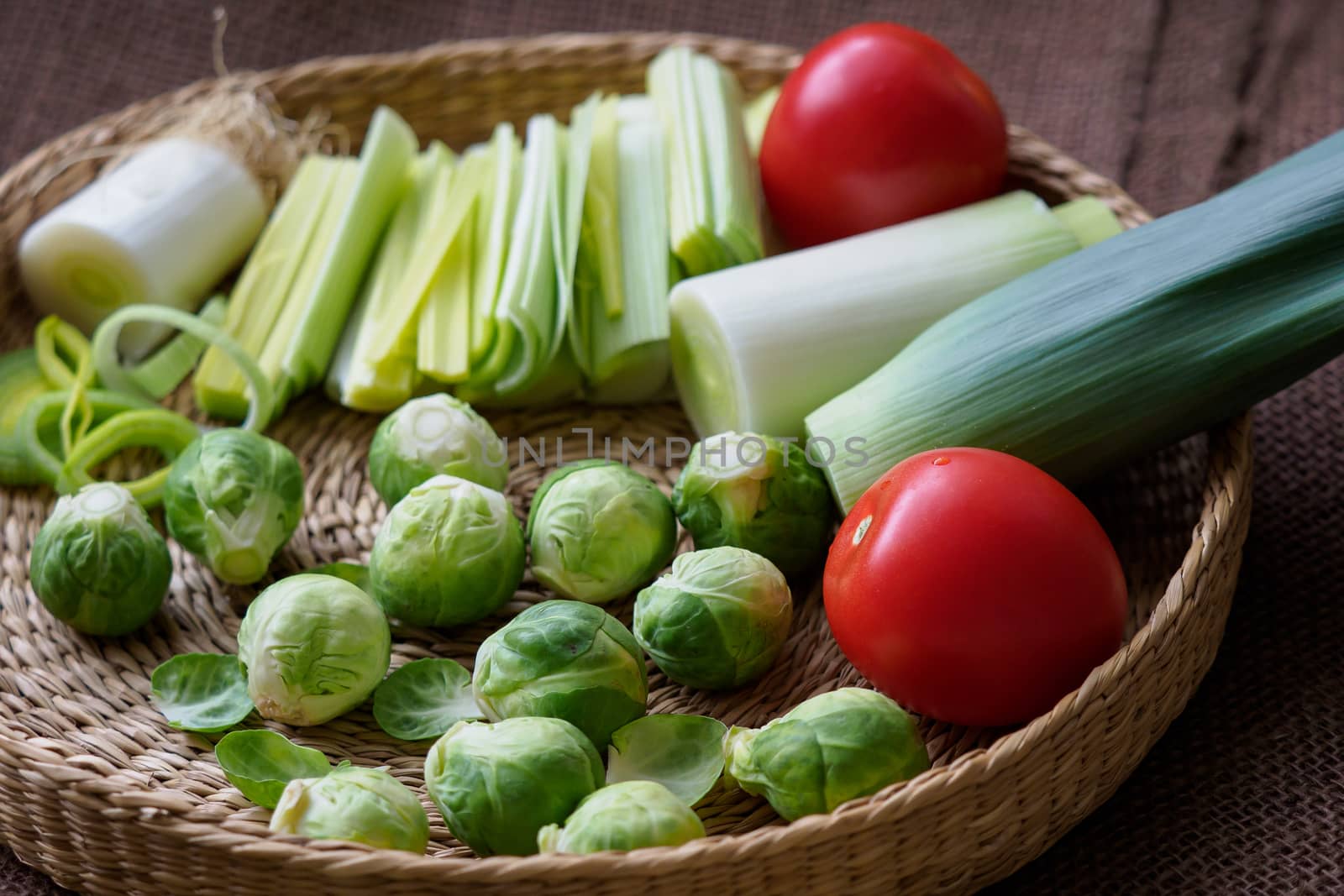 Brussels sprouts (Brassica oleracea) tomato, leek in a basket