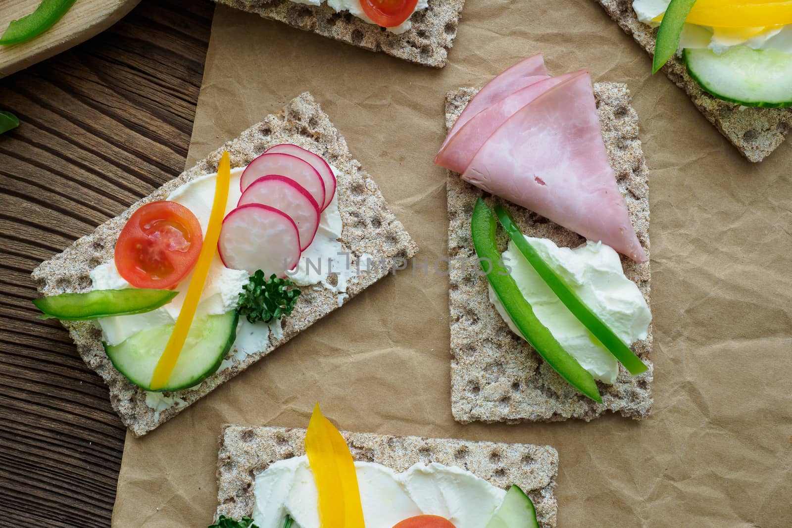 Healthy sandwiches with fresh vegetables. Breakfast toasts on wooden cutting board. Balanced breakfast.