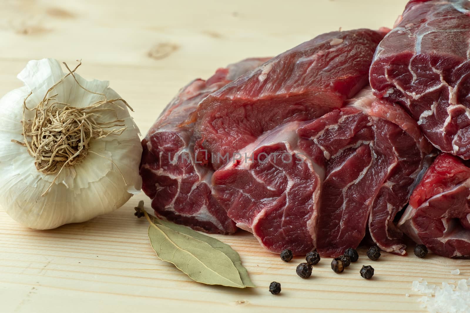 Fresh beef with ingredients for cooking on wooden board