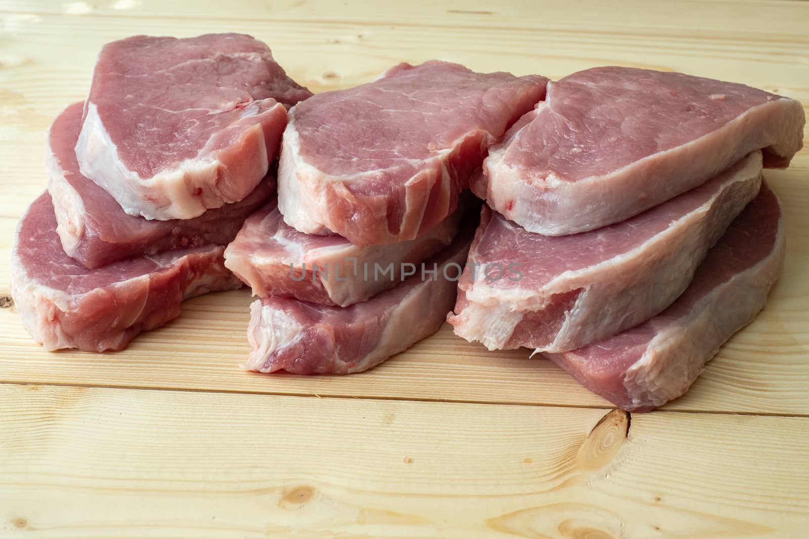 Fresh raw pork slices on wooden board