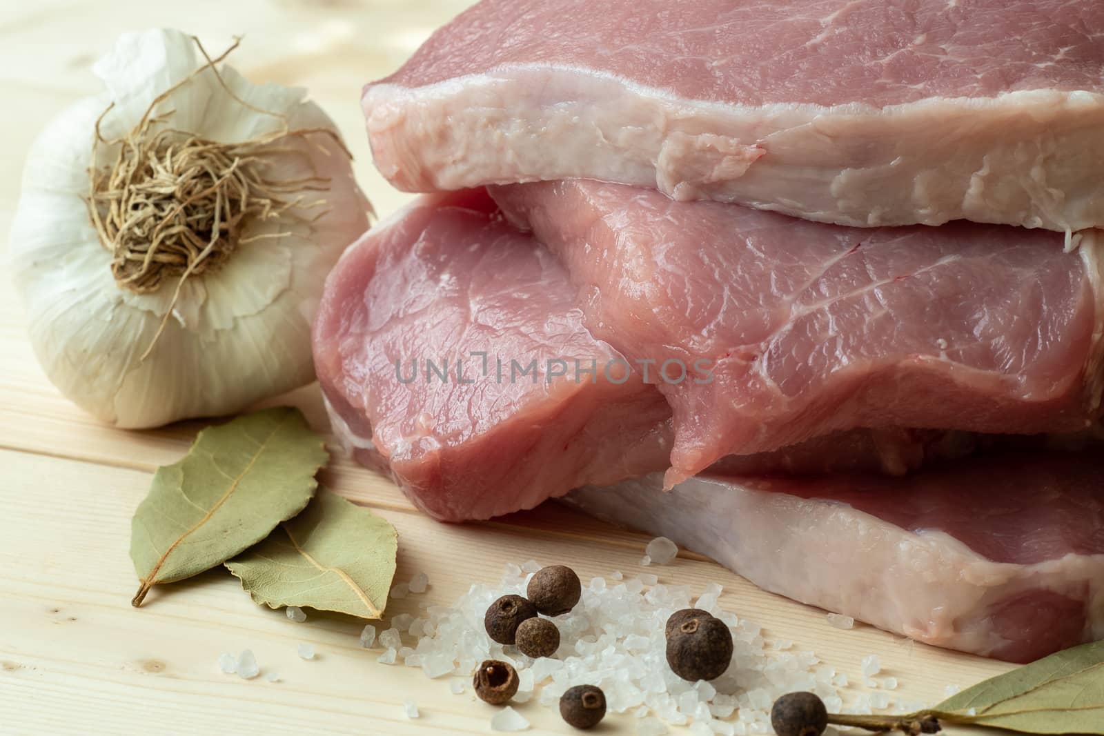 Fresh pork with ingredients for cooking on wooden board