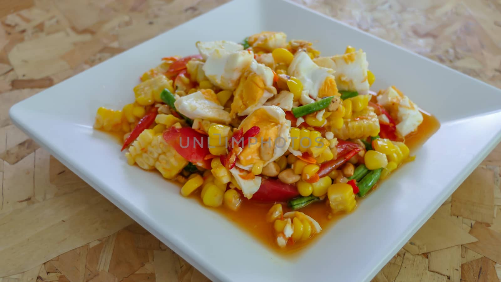 spicy sweet corn salad with salted egg on white dish