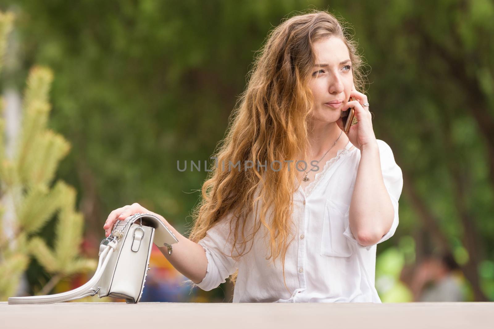 Young girl with a handbag talking on the phone