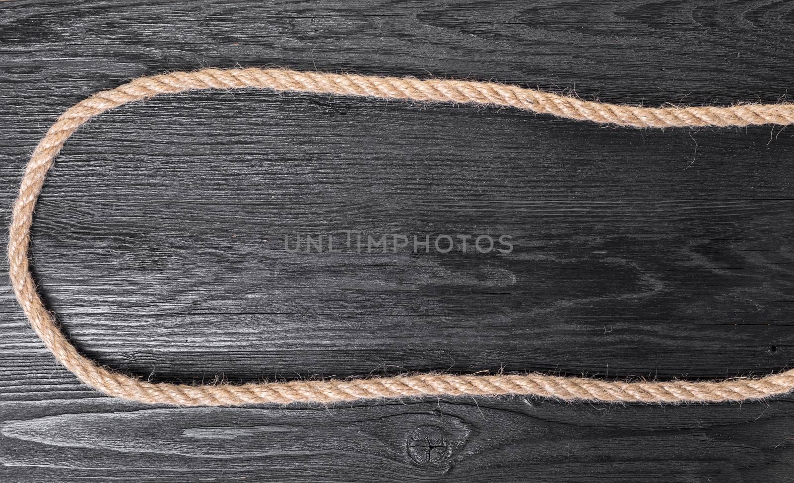 old rope closeup on black wooden background