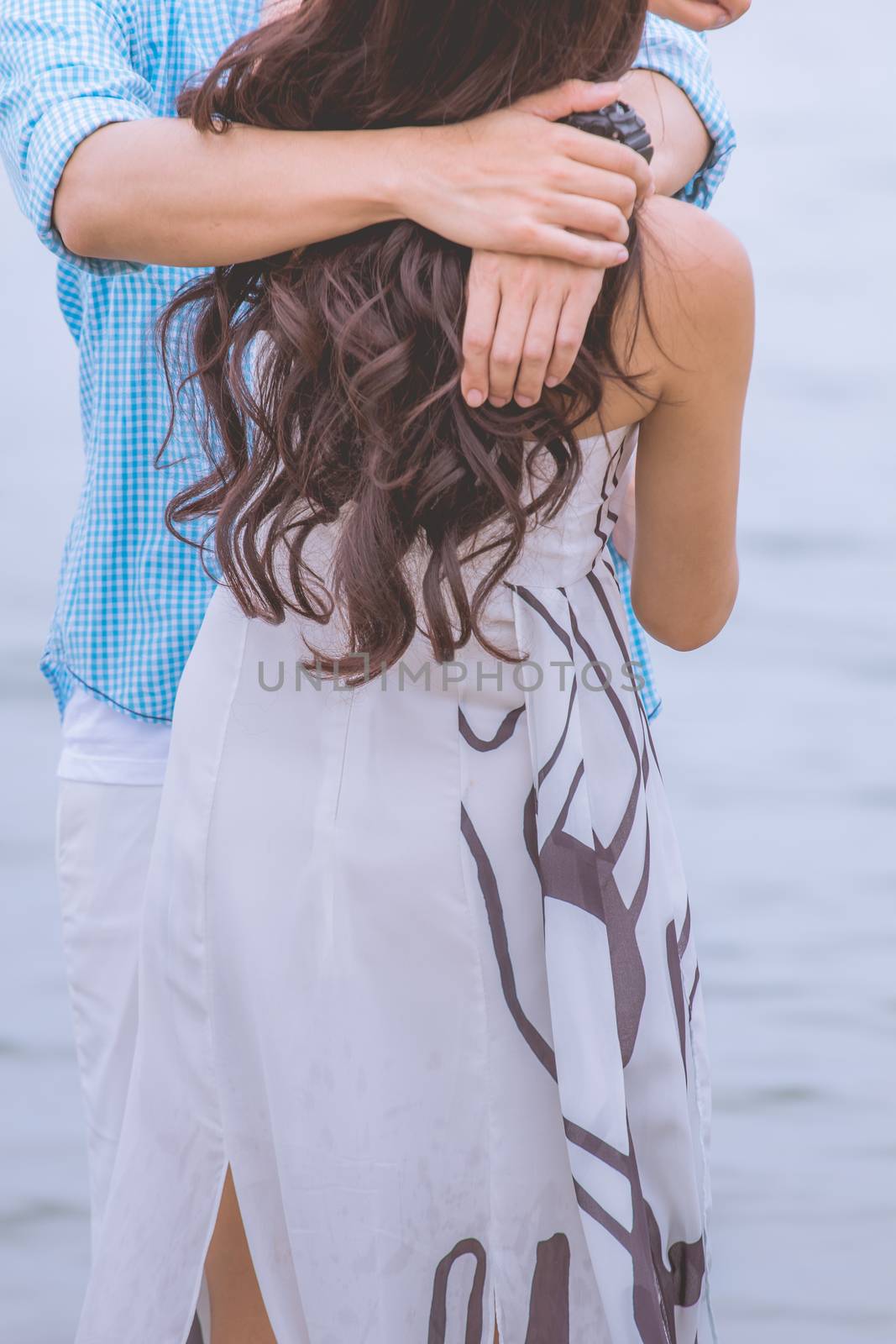 couple on romantic travel honeymoon vacation summer holidays romance. Back rear view of casual young happy lovers in full on beach.