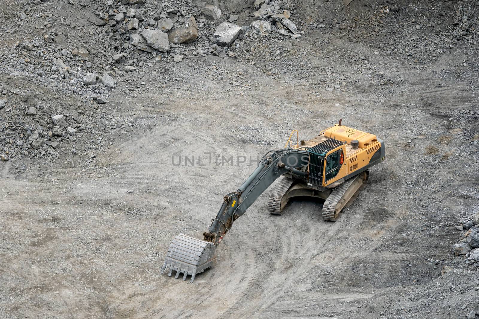 Mining in the granite quarry. Working mining machine - digger. Mining industry.