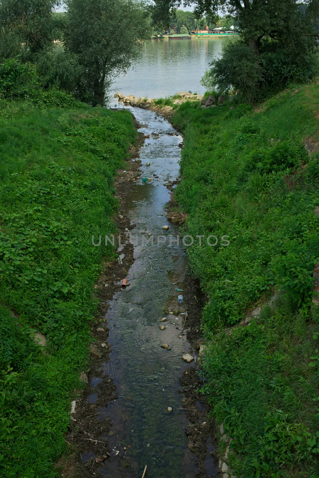 Small water stream flowing into big river Danube