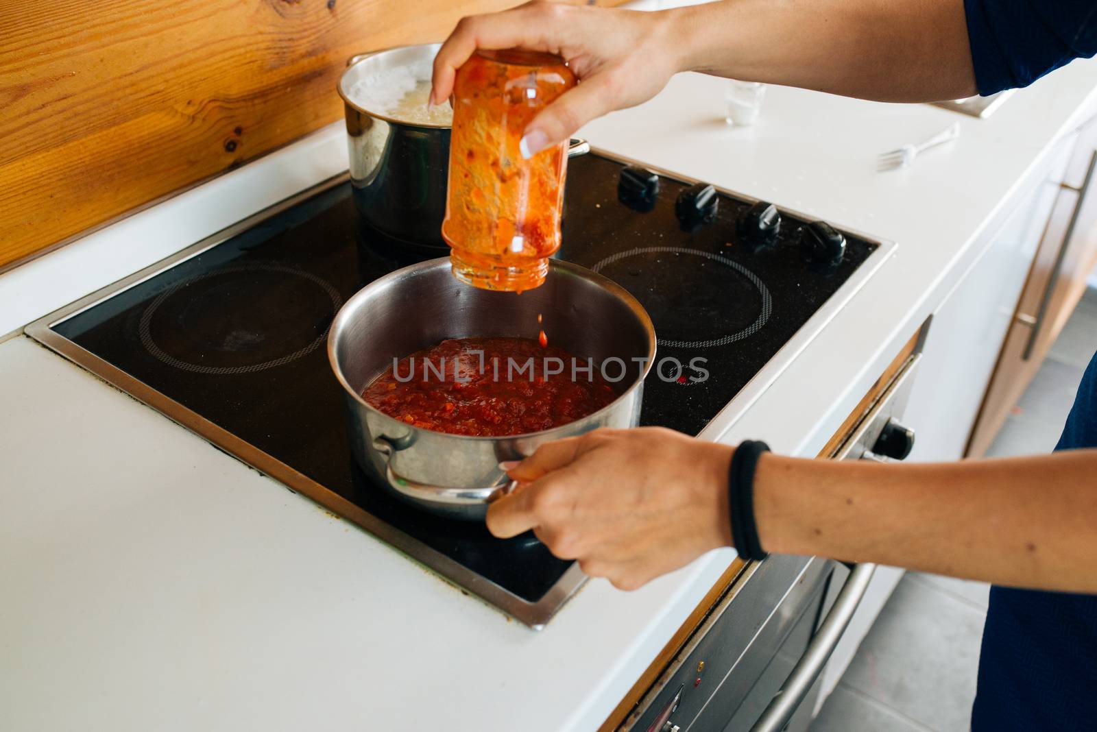 View of Woman Preparing a Tomato Sauce For Pasta in The Kitchen