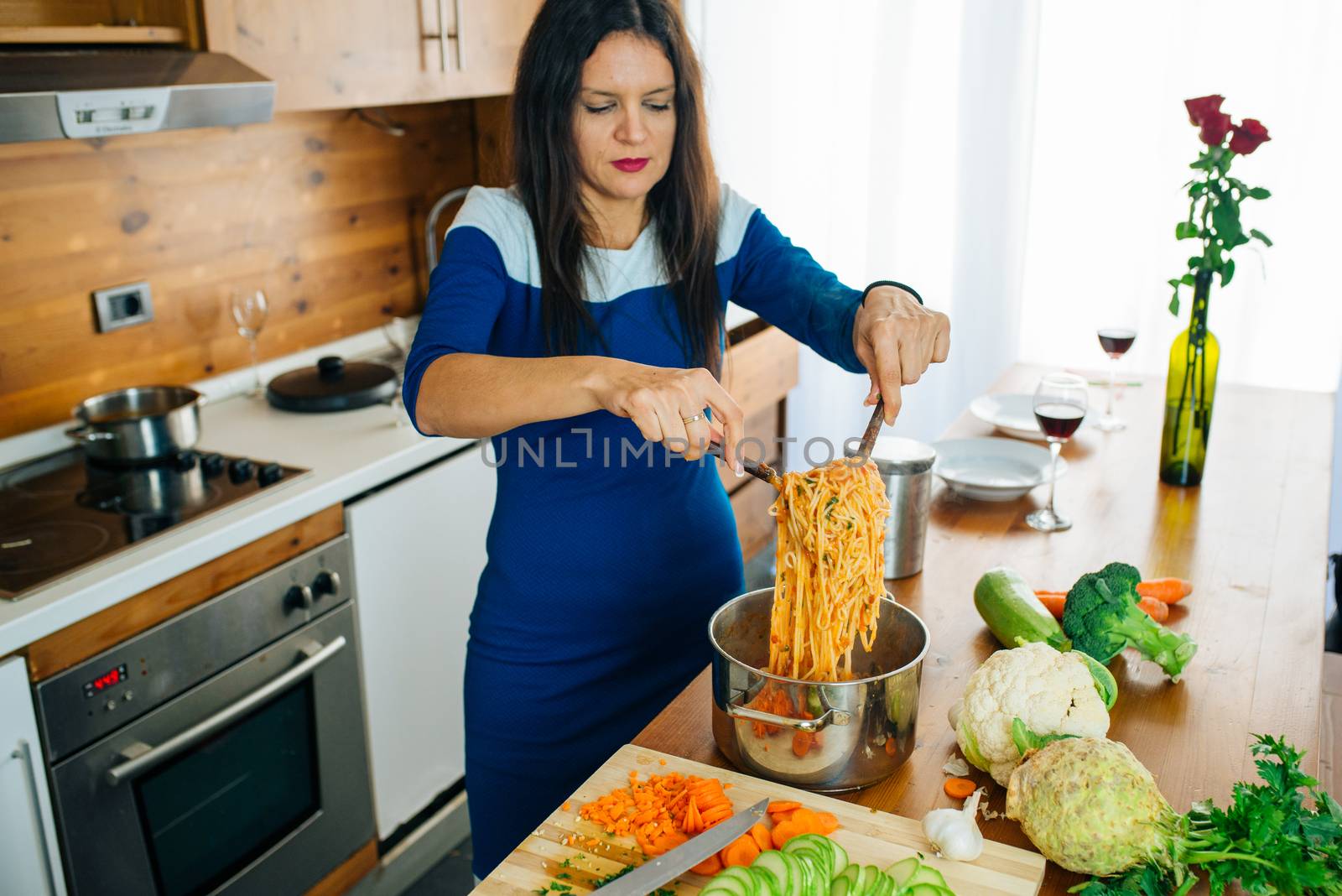 Attractive Woman In Blue Dress Is Preparing Delicious Spaghetti Food In The Kitchen