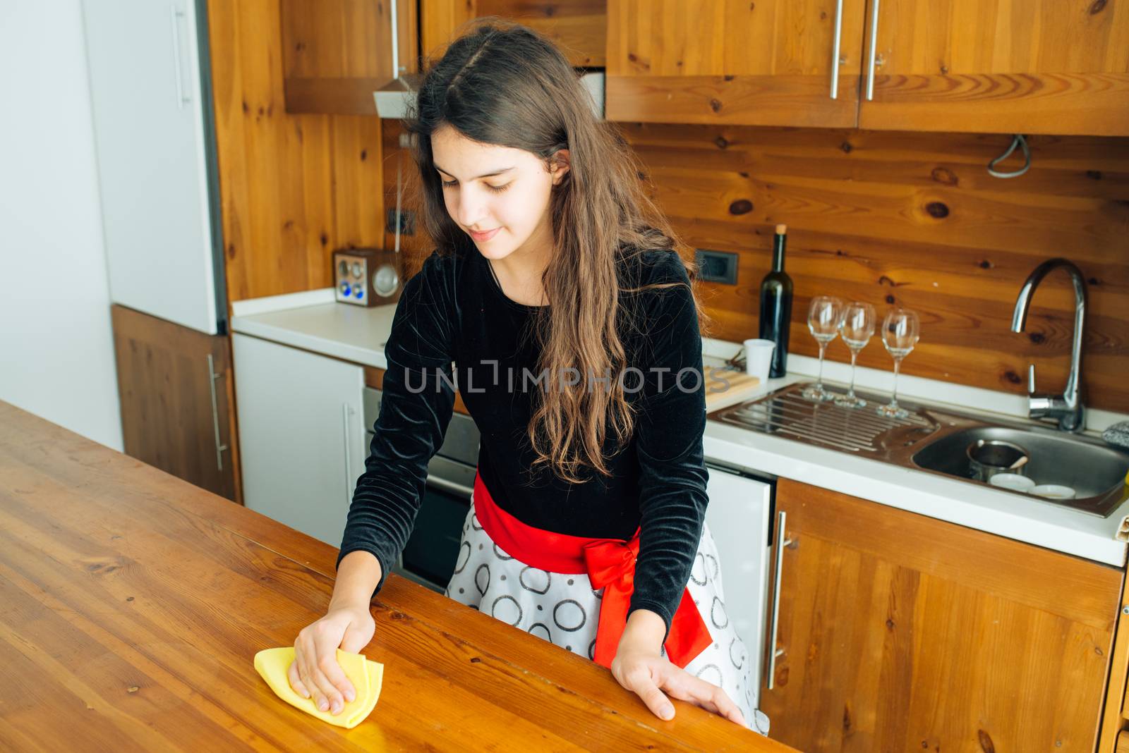 Cute Little Girl Is Cleaning The Kitchen With Yellow Rag