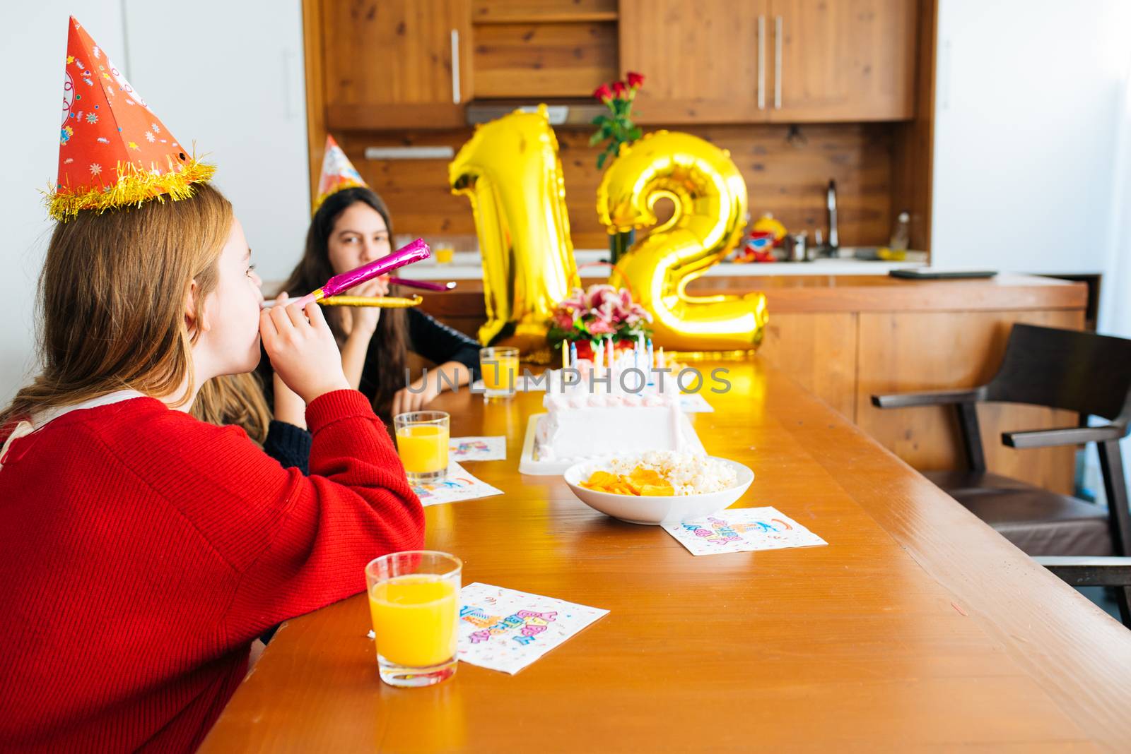 Group of kids celebrate birthday together and blowing in the whistles